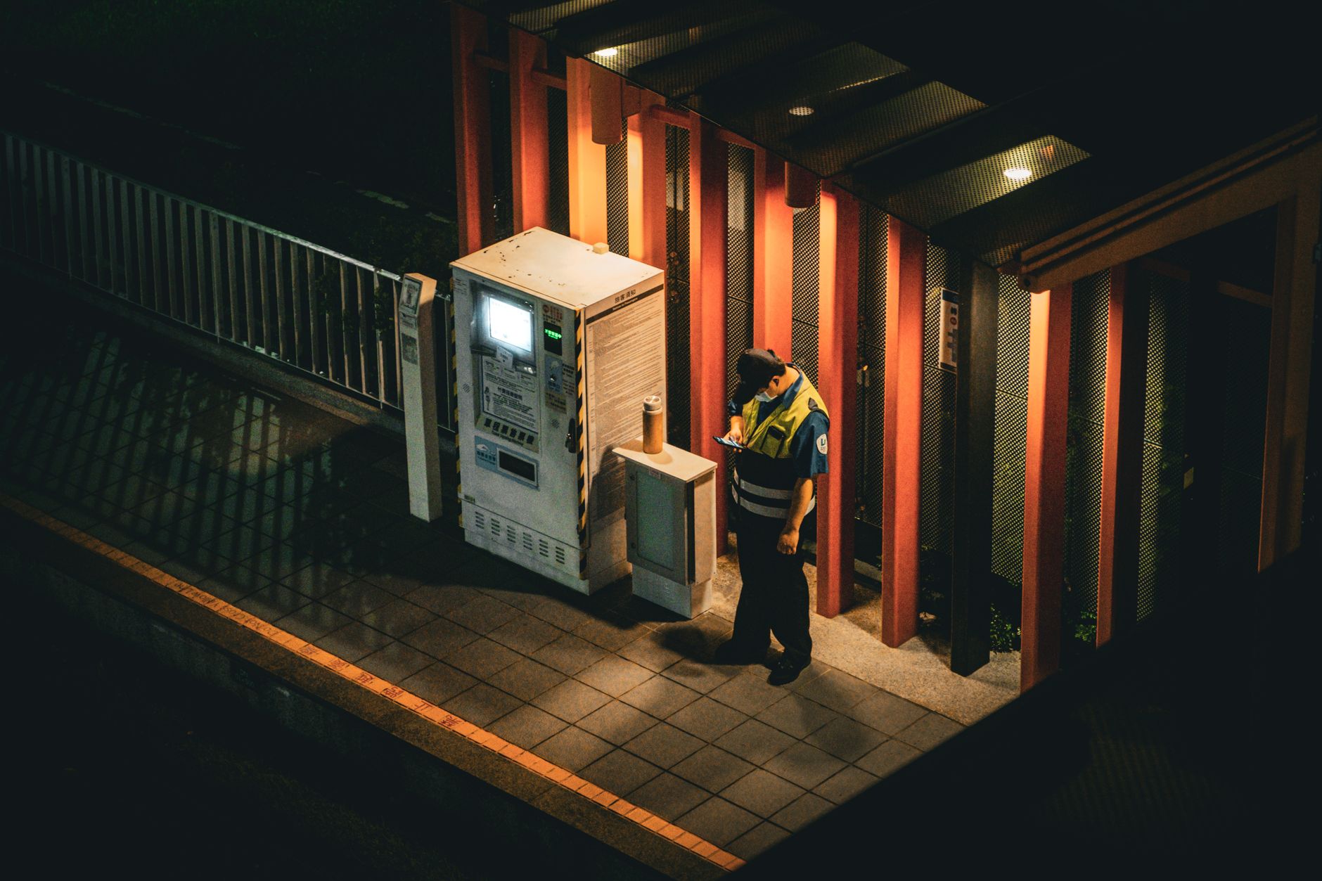 A uniformed security guard standing at the entrance of a commercial building