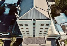 Workers installing roofing materials on a large commercial building