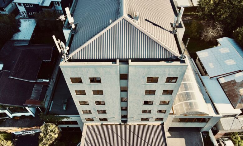Workers installing roofing materials on a large commercial building