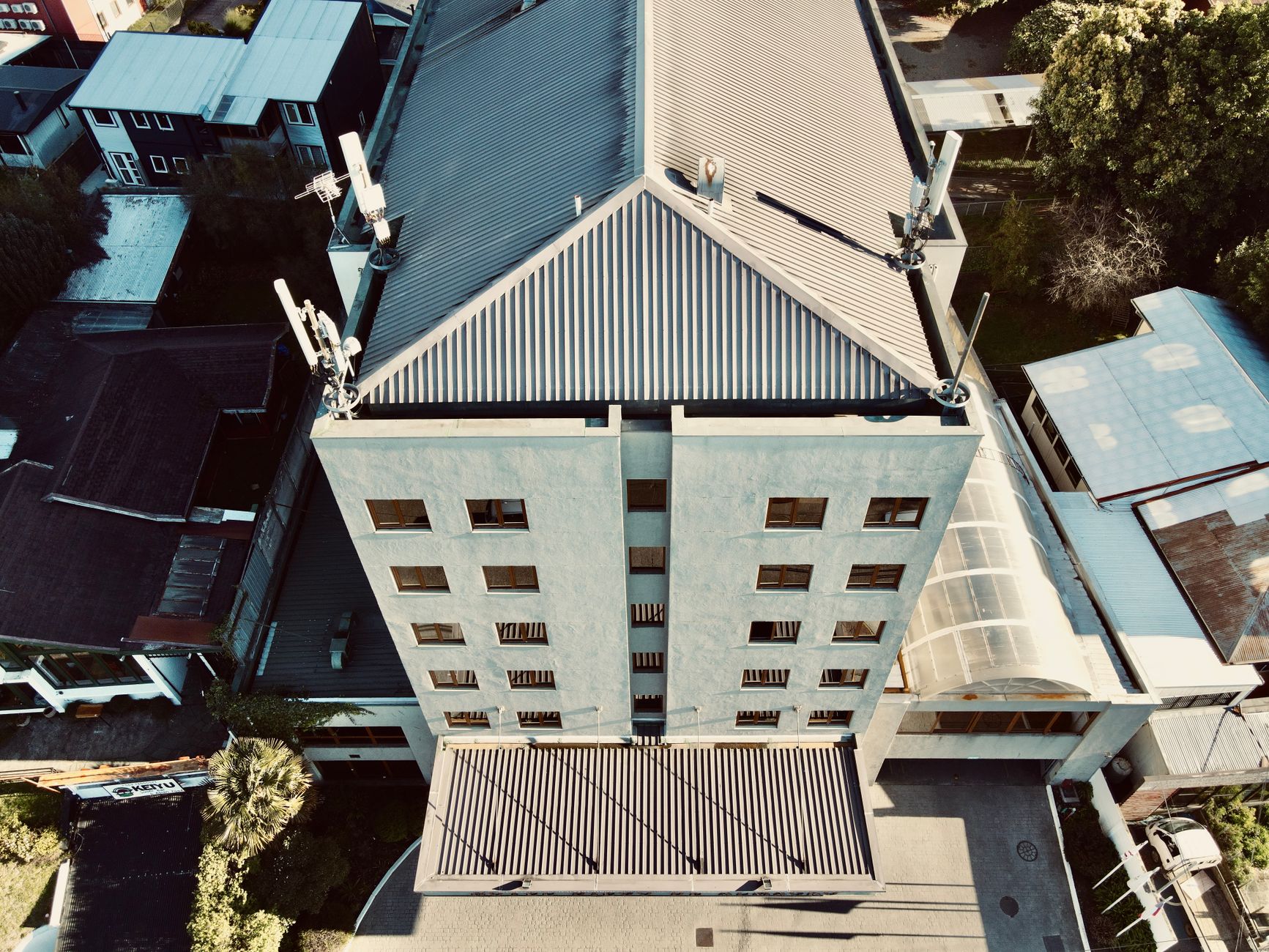 Workers installing roofing materials on a large commercial building