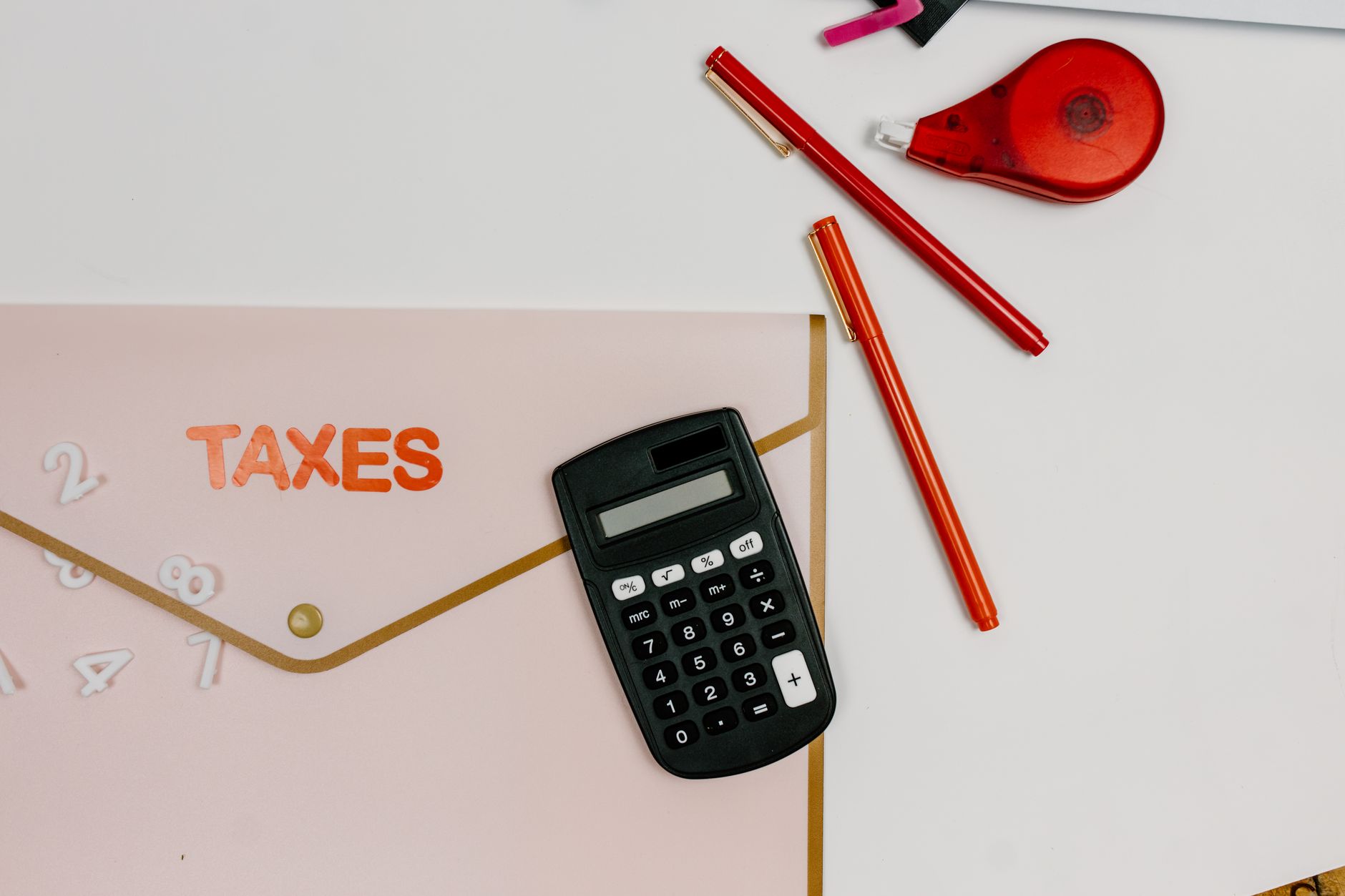 A tax preparer's desk with financial documents and a calculator in a small office setting