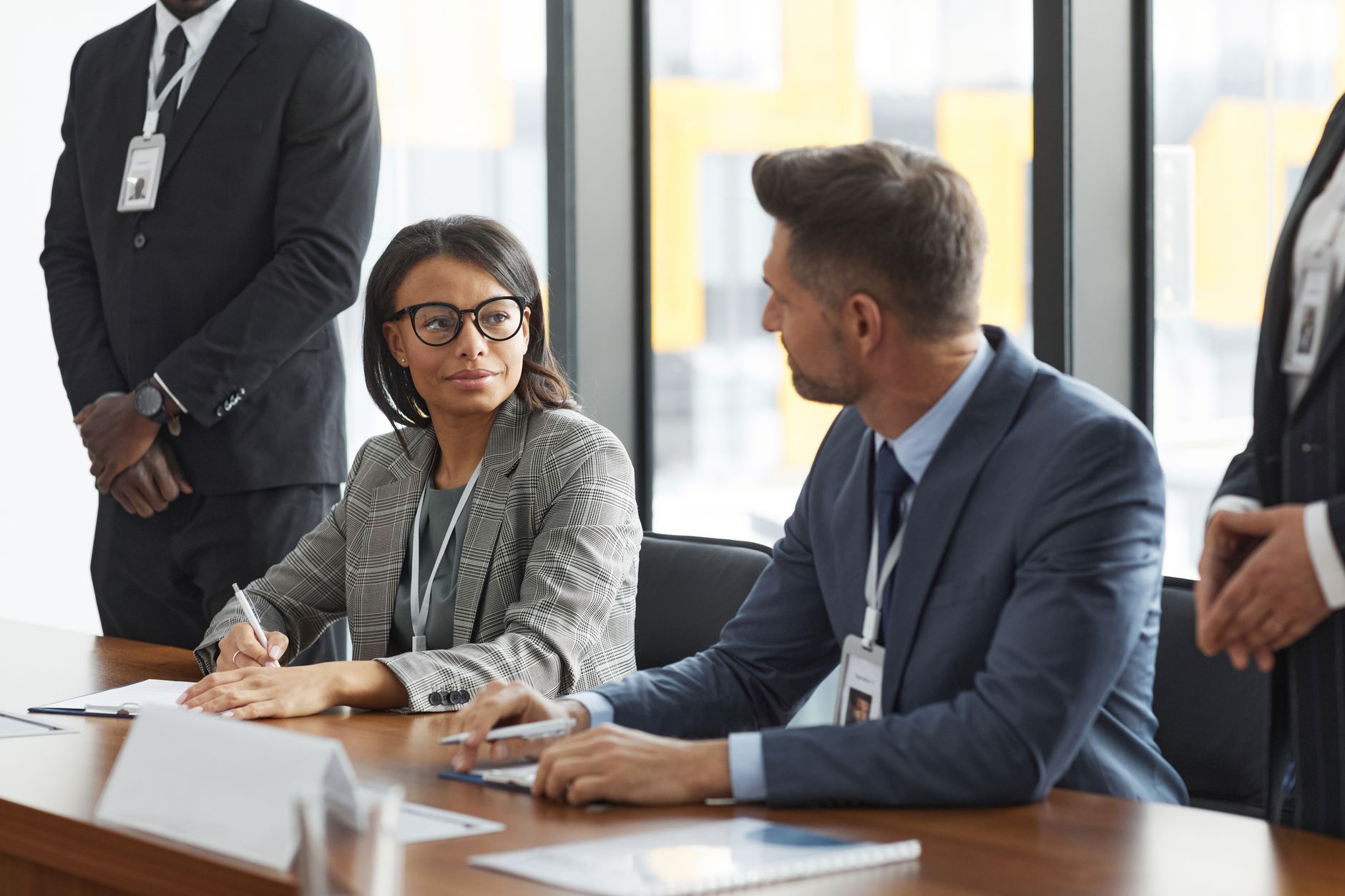 Two professionals reviewing documents during a business acquisition meeting