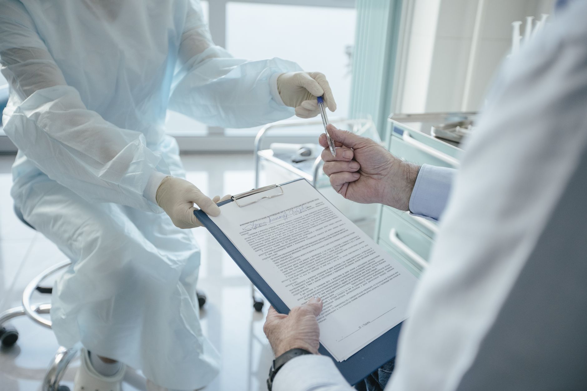 A person reviewing medical documents and contracts at a desk