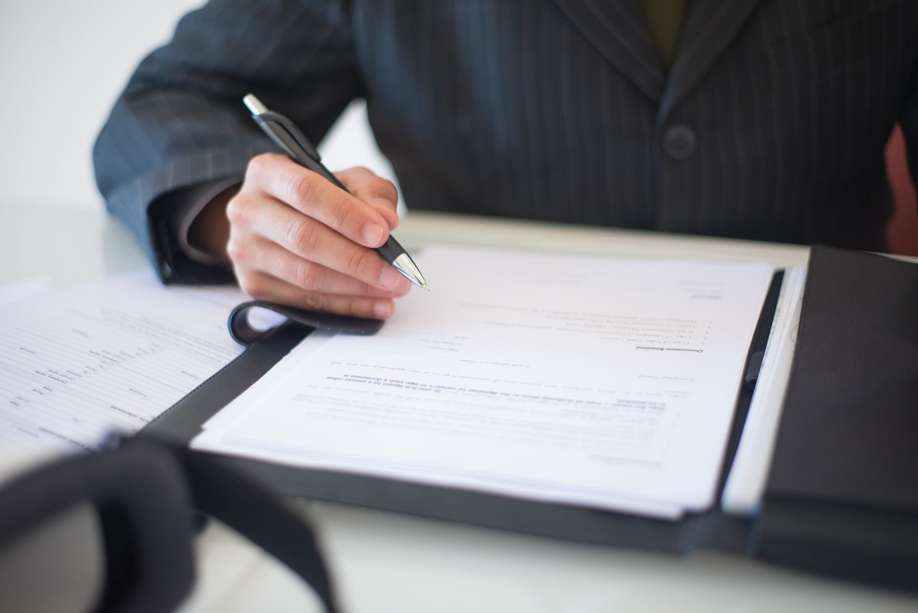 Business documents and contracts laid out on a conference table during a corporate deal