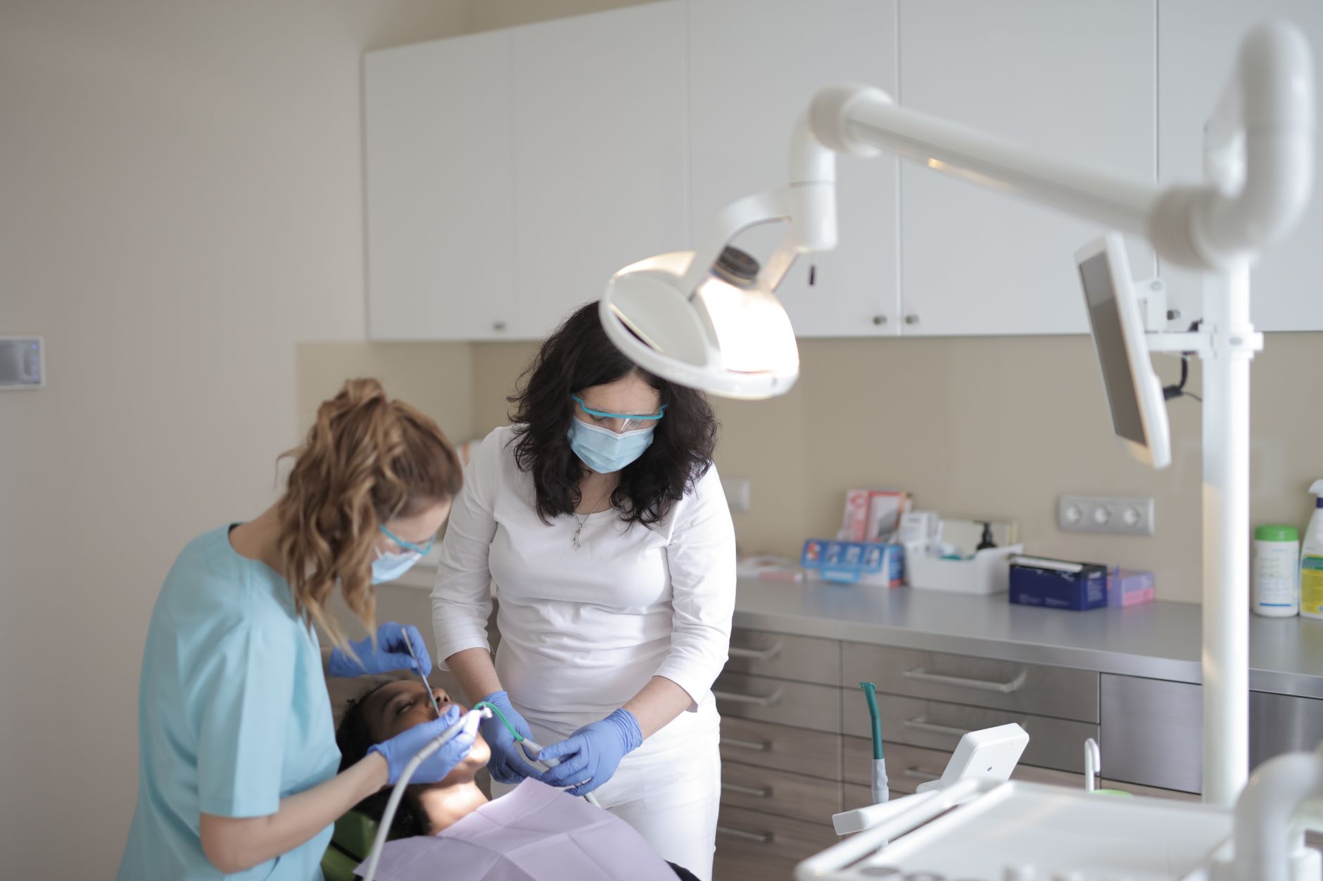 A dentist examining a patient in a clinical dental chair setting
