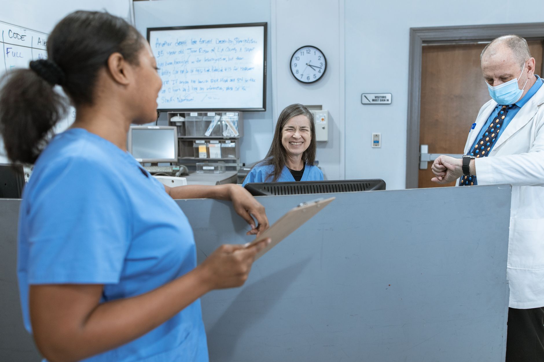 Front desk reception area of a healthcare practice with staff at computers