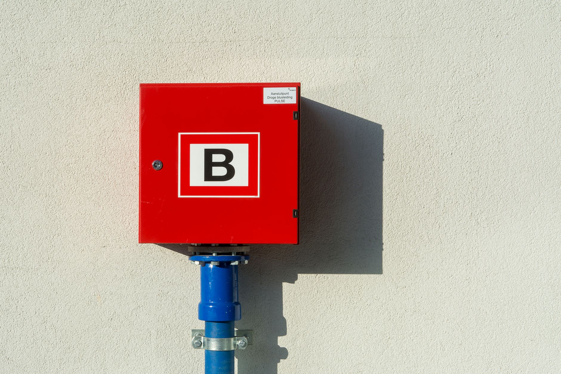 Red fire safety equipment and extinguishers in a commercial building hallway